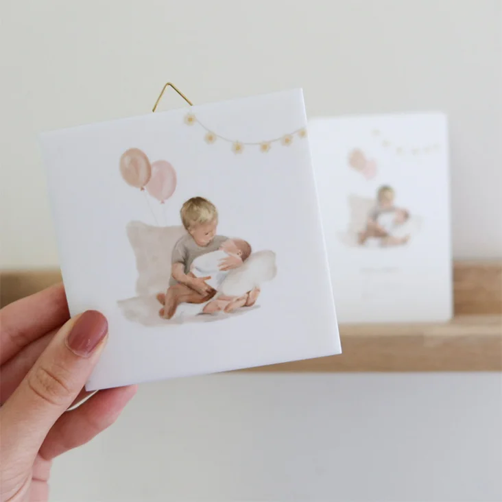Keramieken geboortetegeltje met een illustratie van een kindje met baby